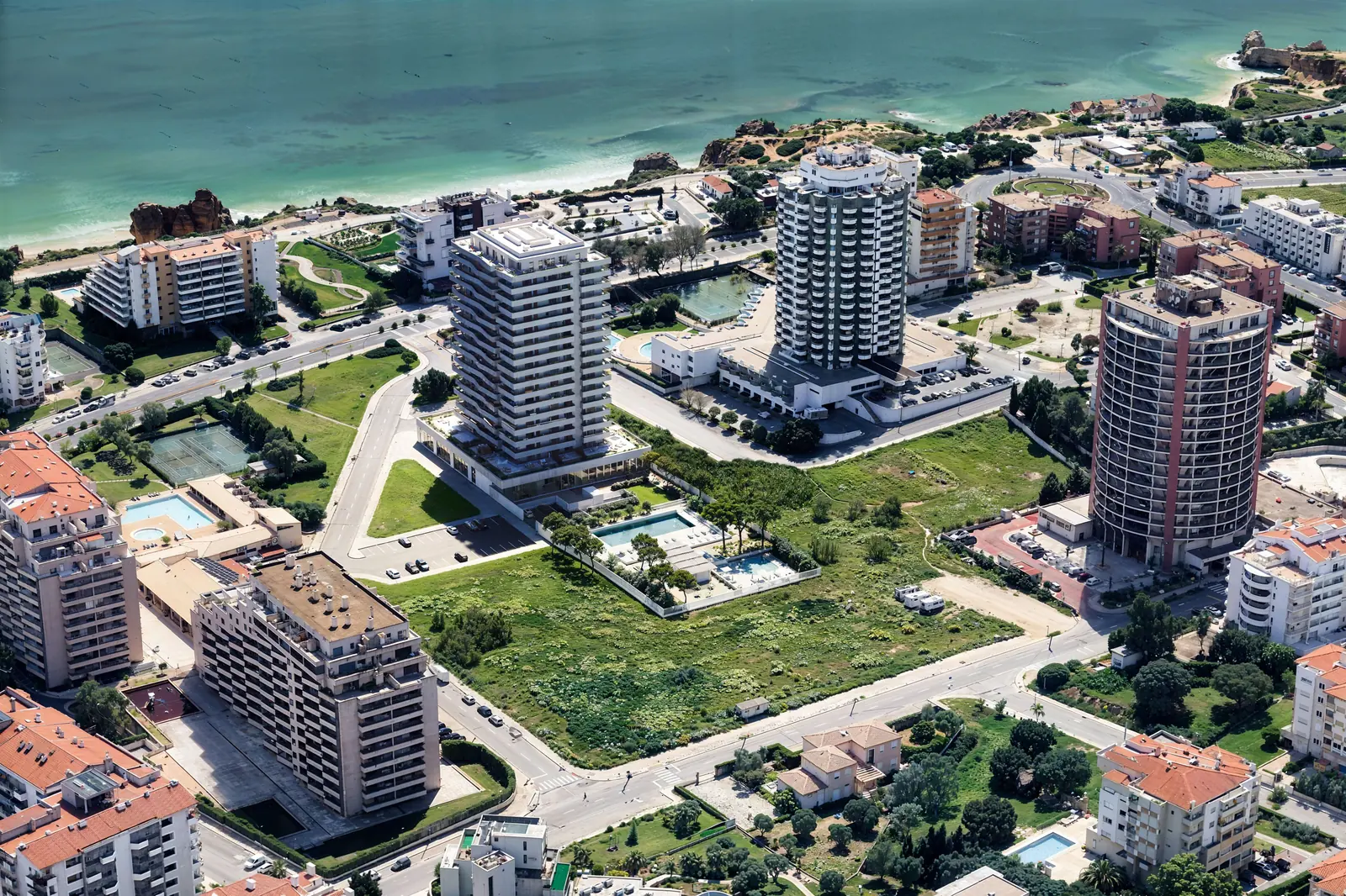 Infografía 3D de integración del conjunto en fotografía aérea de Torre del Algarve, torre residencial en Portimão, Algarve (Portugal) (Saraiva + Associados)